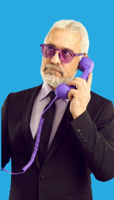 Un-homme-élégant en-costume-et lunettes-violettes-parlant-au-téléphone